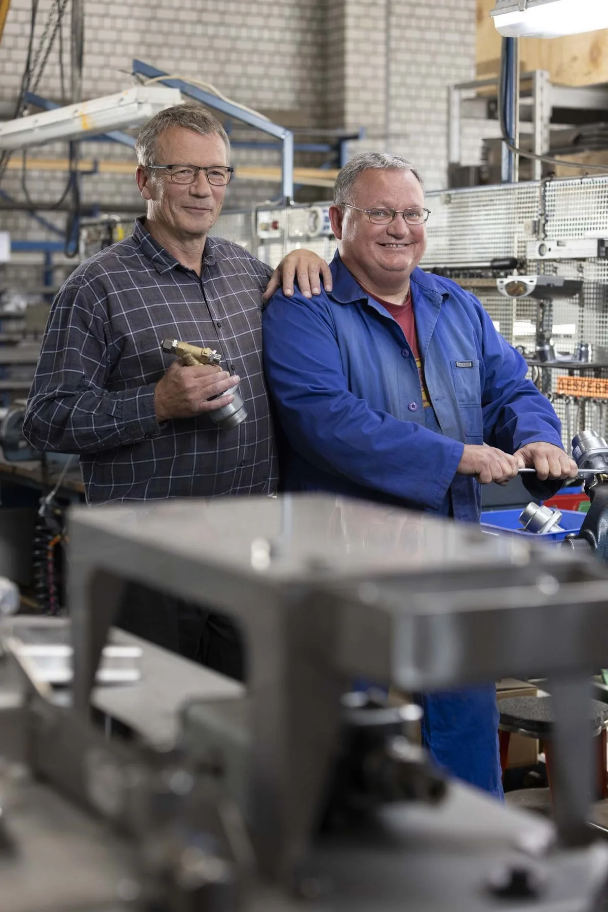 Zwei Monteure vor einer Maschine in der Produktionshalle.